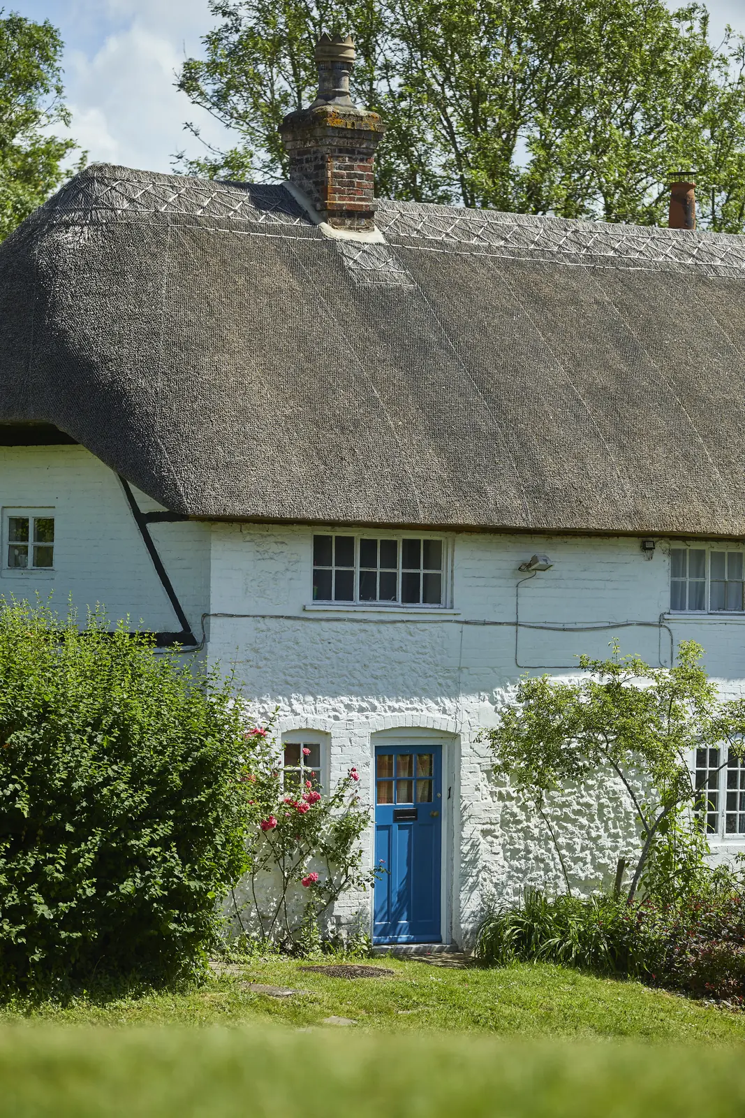 A thatched cottage with a blue door in Ham