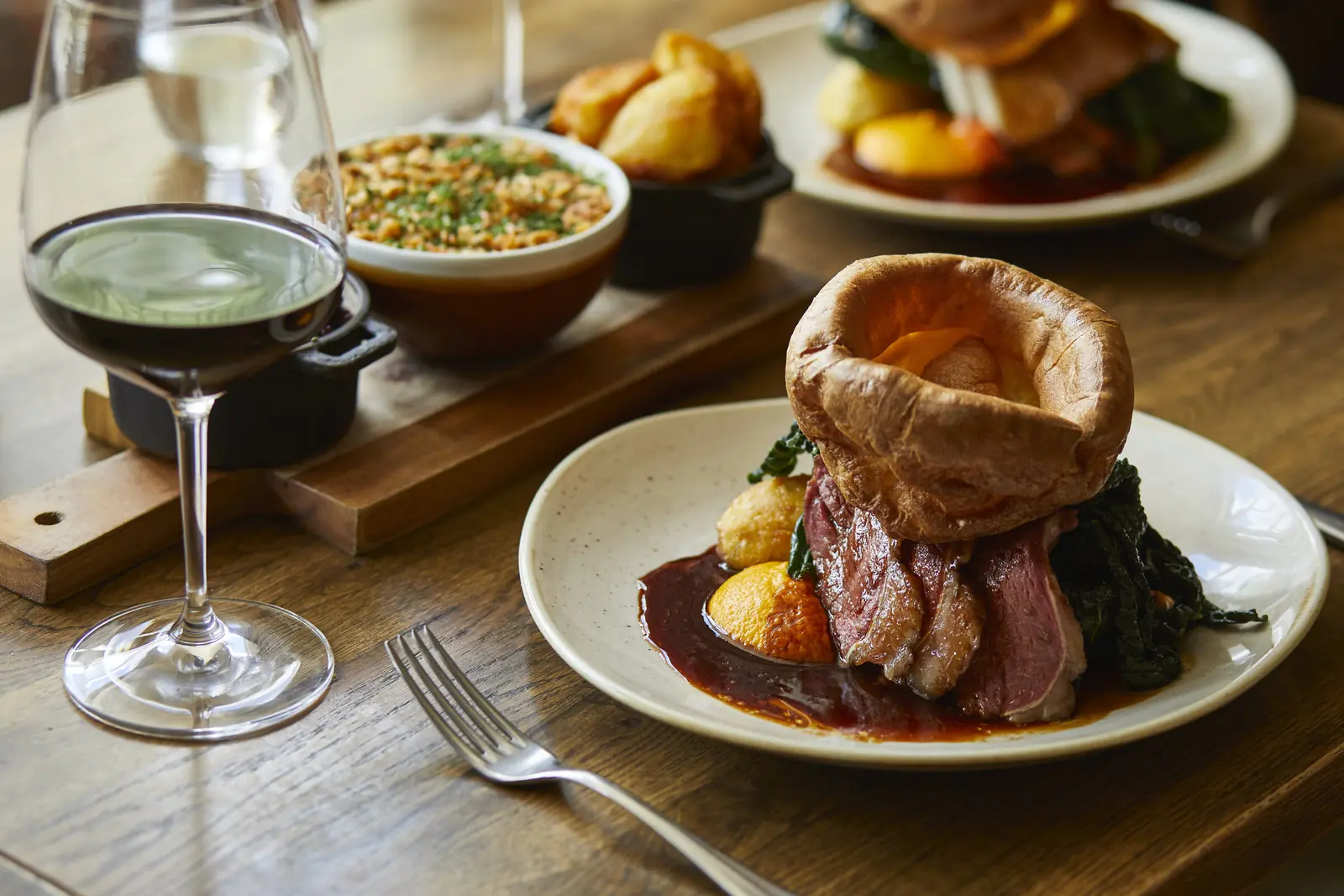 Sunday roast beef with Yorkshire pudding, cauliflower cheese and a glass of red