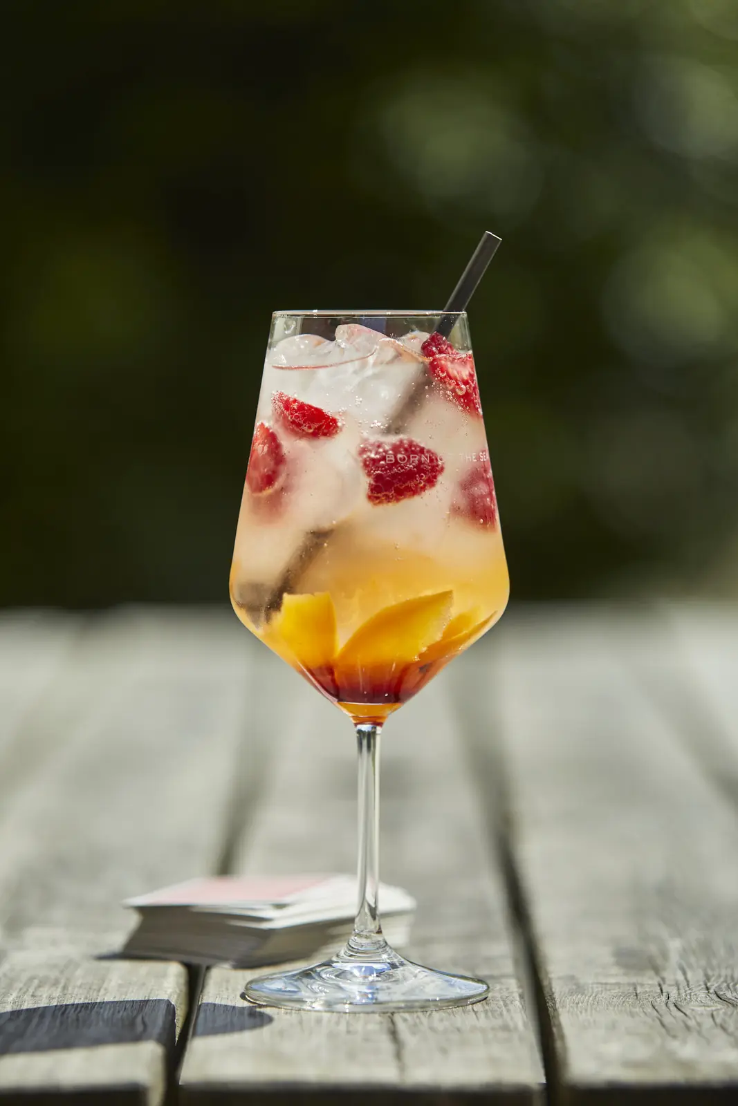 A summer spritz with raspberries on a garden table